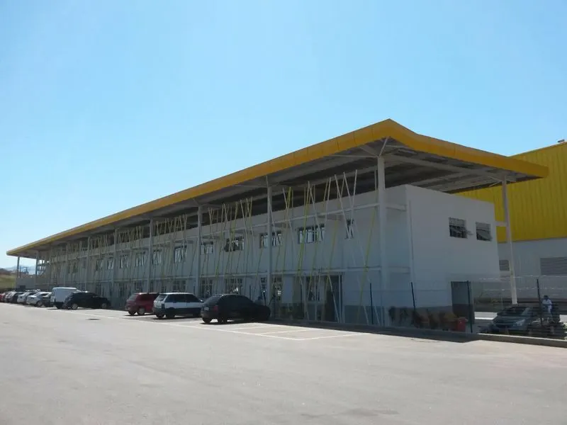 Edifício de apoio de dois pavimentos do CD Casa e Vídeo, em Queimados/RJ, sob cobertura metálica, com estacionamento.