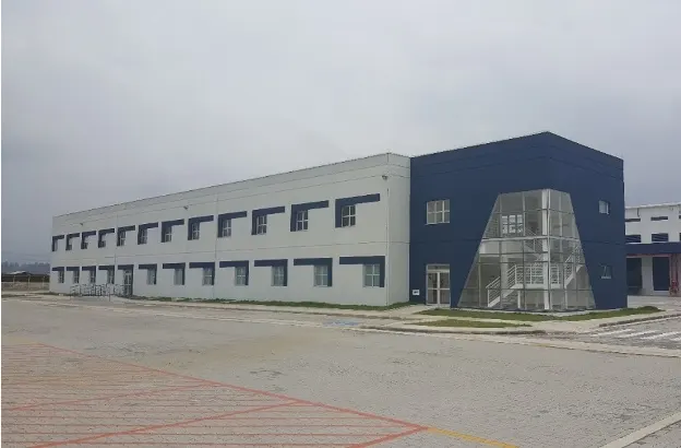Edifício administrativo do Condomínio Logístico BZLog, em Duque de Caxias/RJ, com fachada branca e azul e escada envidraçada.