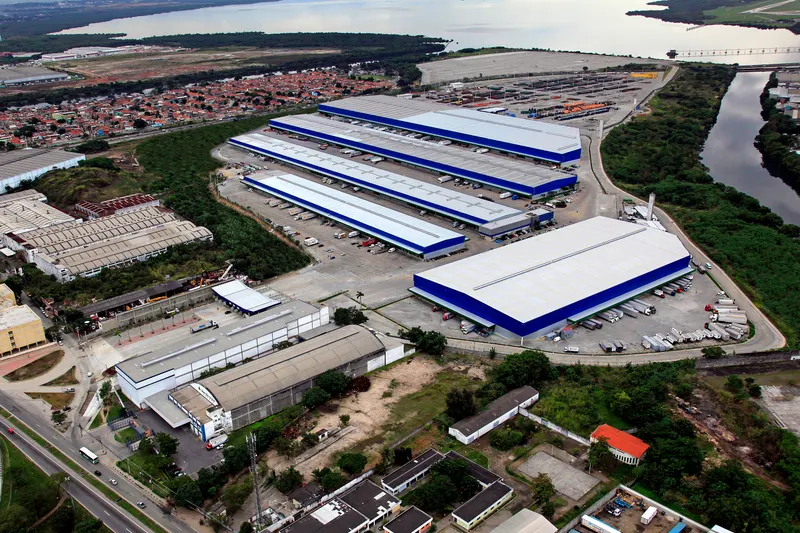Vista aérea do Terminal de Cargas Cargo Park, no Rio de Janeiro/RJ: galpões, pátios e a baía ao fundo.