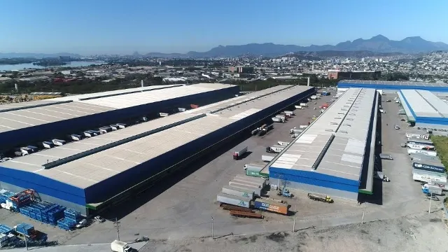 Imagem de drone dos galpões do Terminal de Cargas Cargo Park com docas e carretas no pátio